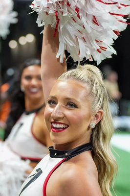 Generic blond cheerleader shaking her pom poms in support of the Falcons. Funny how they made the uniform look like there is a dog collar around her neck.