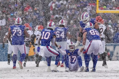 The receiving corps helps Josh Allen up after a snowy trip to the turf in the first half of the game.