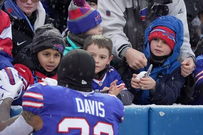 Ray Davis makes some early Christmas wishes come true as he signs autographs for a group of young fans.