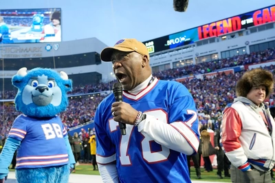 Thurman Thomas, wearing the jersey of absent friend Bruce Smith, fires up the crowd at Highmark as the Bills prepare to take the field before their final game there.